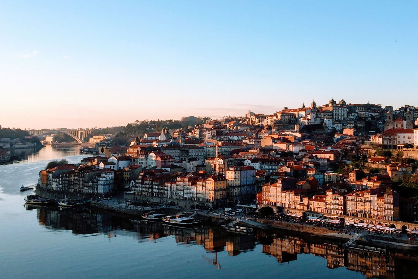 A stunning sunset over Porto, Portugal, highlighting the historic Ribeira district and the Douro River.