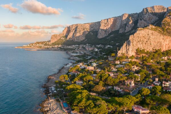 Aerial view of the Mondello coastline near Palermo, Sicily, with villas and pine trees beneath the cliffs of Monte Gallo