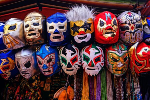 Rows of colorful Lucha Libre wrestling masks displayed for sale at a market stall in Mexico City