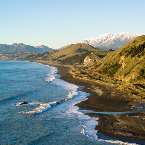 New Zealand 2025_Scenic view of Kaikōura’s rugged coastline and snow-capped Seaward Kaikōura Range meeting the Pacific Ocean, a stunning South Island landscape.