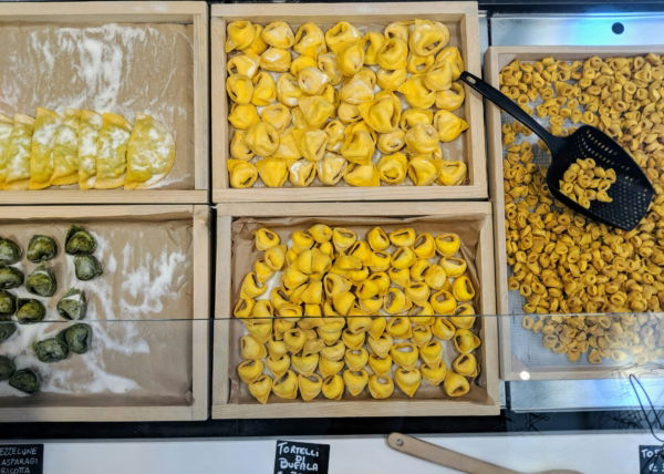 Trays of hand-folded fresh tortellini and tortelli pasta at a shop in Emilia-Romagna, Italy