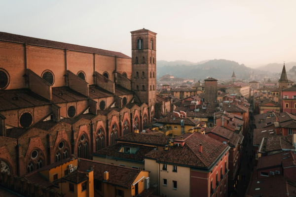 Aerial view of Bologna's terracotta rooftops and Basilica di San Petronio bell tower